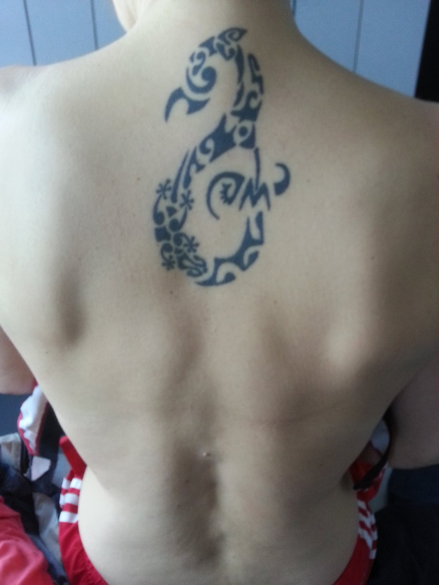 Polynesian manaia tattoo on a woman's upper back: inked placement real user tattoo photo