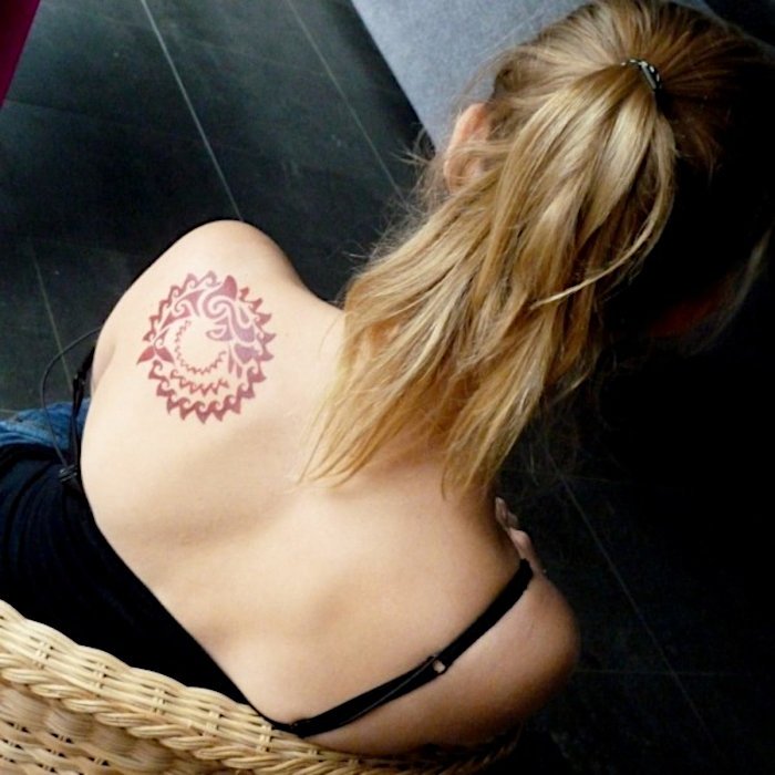 Tribal dolphin tattoo encircled by a tribal sun: inked placement real user tattoo photo